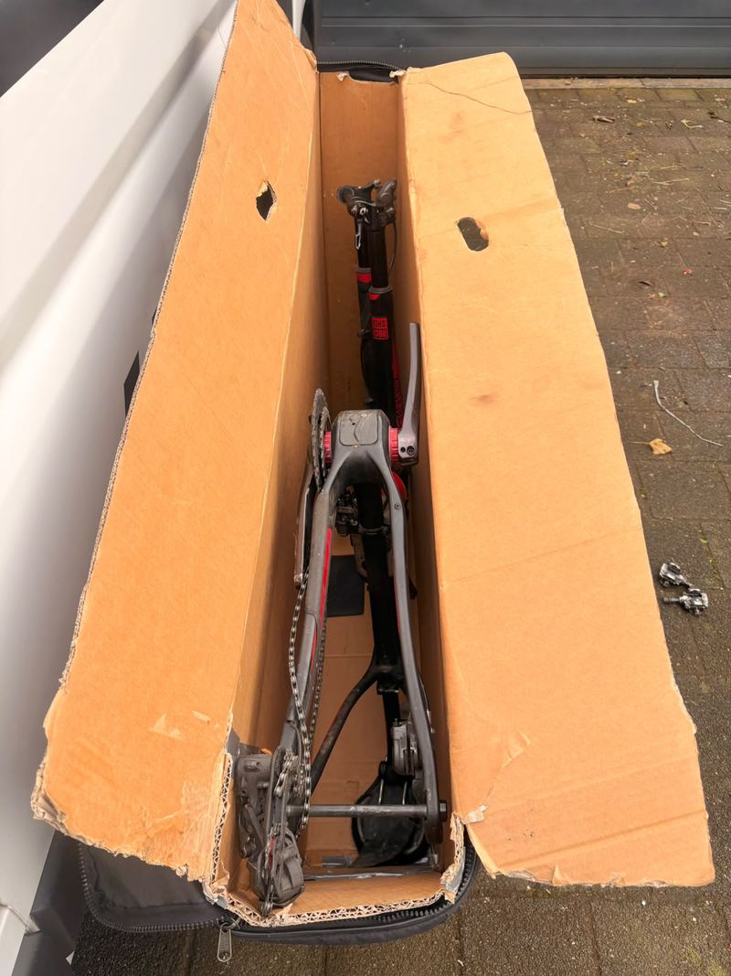 Fiets zonder wielen in een open kartonnen fietsdoos